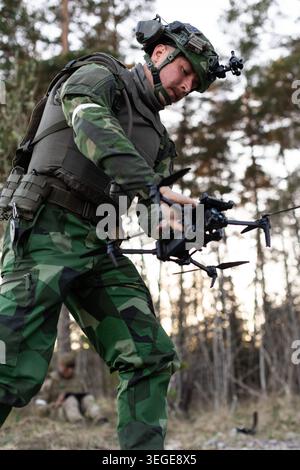 Un opérateur de drone de l'armée suédoise récupère un drone de reconnaissance quadcoptère sur l'île de Gotland en Suède lors de l'exercice Aurora 26. Les forces armées ukrainiennes ont envoyé des opérateurs de drones en Suède pour Aurora 26 afin de transmettre les leçons apprises à leurs homologues de l’OTAN, tout en fournissant une force adverse difficile aux soldats alliés. Les précédentes itérations d’Aurora, série d’exercices militaires menés par la Suède, axées sur la mobilisation des forces armées du pays pour la défense nationale, ont également cherché cette année à tester la capacité de la Suède à intégrer les forces alliées dans ces plans. Plus de 18 000 soldats de 13 pays y ont participé Banque D'Images