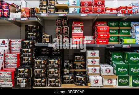 Emballages multiples de bières en conserve et en bouteille stockés sur les étagères des supermarchés à Dublin, en Irlande, avec des étiquettes de prix de détail affichées sous les articles. Banque D'Images
