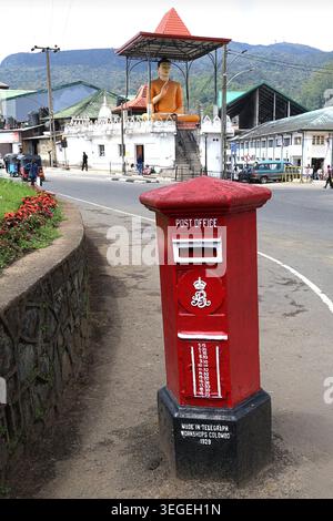 Boîte aux lettres victorienne rouge devant le bureau de poste Nuwara Eliya, Sri Lanka dans le centre-ville - en arrière-plan est une grande statue du Bouddha Banque D'Images