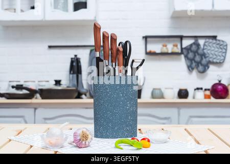Conteneur de couteau moucheté coloré avec poignées en bois et outils culinaires assortis Banque D'Images