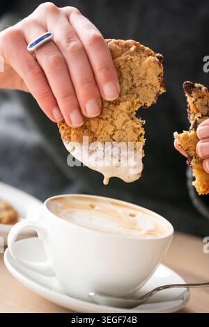 Dégustez un biscuit chaud aux pépites de chocolat accompagné d'une tasse de café à la vapeur Banque D'Images