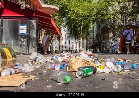 Paris, France - 22 juin 2025 : de nombreux déchets ménagers, ordures et emballages en plastique jonchent le sol dans une rue du centre-ville de Paris. Banque D'Images