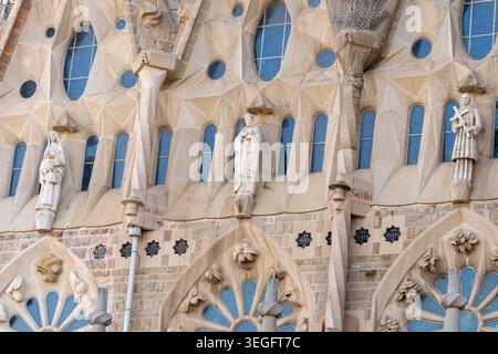 BARCELONE, ESPAGNE - 19 MAI 2026 : détail architectural de sculptures en pierre de saints et l'inscription rouge Sacrificium près des vitraux Banque D'Images