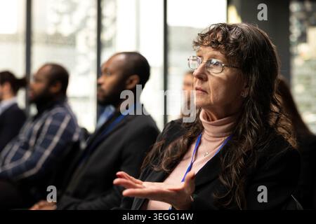 Femme âgée étant confuse et mal comprise le pitch pendant l'événement, en prêtant attention à la présentation dans la salle de conférence. Sommet international de la convention avec des gens d'affaires. Banque D'Images