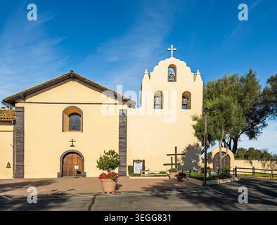 Solvang, Californie, États-Unis - 21 mars 2026 : Old Santa Ines Mission bâtiment de l'église catholique sous la lumière du soleil du matin et le ciel bleu avec arbre sur le côté Banque D'Images