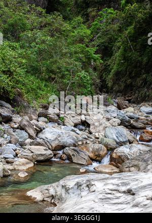 Lit rocheux de la rivière Sanzhanxi à Taroko. Gros rochers gris et ruisseau coulant. Forêt verte dense sur les parois abruptes du canyon. Hualien, la côte est de Taiwan. Banque D'Images