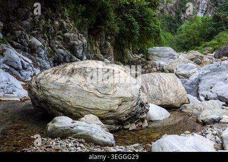 Grands rochers de marbre dans le lit de la rivière Sanzhanxi. Une végétation luxuriante pousse sur les falaises. De l'eau claire coule autour des pierres à Hualien. Banque D'Images
