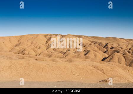 Vue panoramique des collines désertiques érodées dans la région de Maranjab près de Kashan, Iran, au coucher du soleil sous un ciel bleu clair, mettant en évidence la géologie aride, tex naturel Banque D'Images