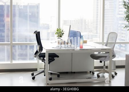 Intérieur de bureau moderne vide avec bureaux et vue sur la ville Banque D'Images