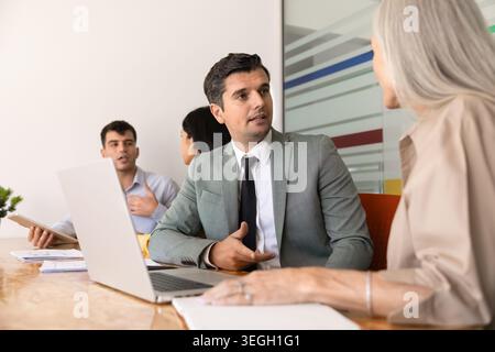 Homme d'affaires parlant avec une collègue femme à la table de conférence Banque D'Images
