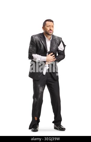 Homme d'affaires blessé dans un costume déchiré et sale tenant son estomac isolé sur fond blanc Banque D'Images