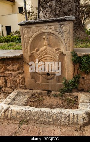 Une petite fontaine publique inactive de style byzantin. Une fontaine à boire inactive. Athènes, Grèce Banque D'Images