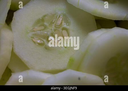 Rondelles de concombre frais tranchées préparées pour une salade rafraîchissante. Banque D'Images