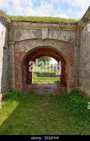 Arc de pierre encadrant le paysage vert dans les ruines de la forteresse antique. Banque D'Images