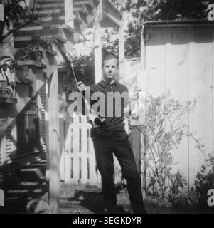 Lee Harvey Oswald (1939–1963) posant avec un fusil Carcano et des journaux marxistes dans son jardin à Dallas, Texas, le 31 mars 1963. Il a été arrêté pour l'assassinat de John F. Kennedy, 35e président américain, huit mois après la prise de cette photo. Banque D'Images
