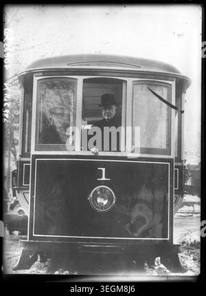 Thomas Edison est assis à la fenêtre d'un tramway en 1913, enregistré dans une photographie de presse monochrome montrant l'inventeur dans un cadre de transport en commun au début du XXe siècle. Banque D'Images