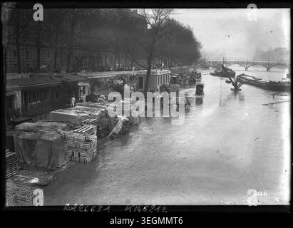 La Seine s'élève le long du Louvre à Paris lors des inondations de 1913 ; photographie de presse documente les niveaux d'eau sur les quais et l'état des rivières urbaines dans la ville à cette époque. Banque D'Images