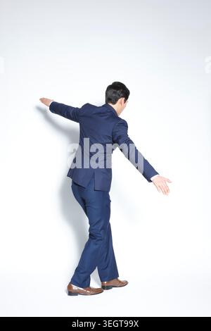 un homme d'affaires en costume bleu montrant des gestes avec ses mains Banque D'Images