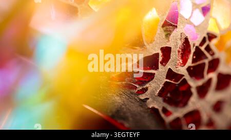 Gros plan en mosaïque colorée avec vitraux rouges et morceaux de cristal irisé en vue macro Banque D'Images