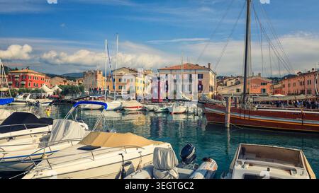 Bardolino, Italie - 20 mai 2026 : cette photo en grand angle capture le port animé de Bardolino sur le lac de Garde avec des bateaux traditionnels et une archite historique Banque D'Images