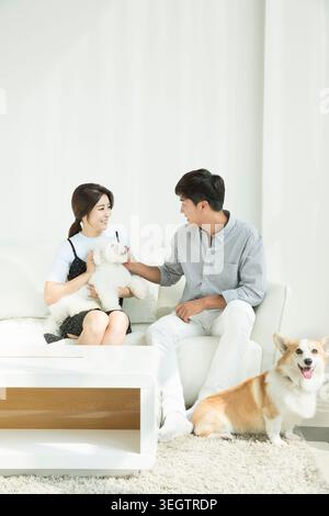 Young smiling couple avec les chiens de compagnie Banque D'Images
