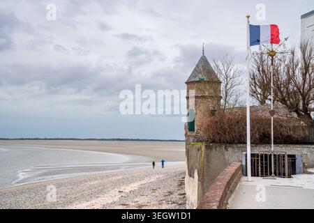 Une vue sur la promenade le Crotoy avec une tourelle de briques caractéristique à côté d'un mémorial avec le drapeau français. En arrière-plan, le vaste sablonneux b Banque D'Images