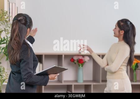 Agent immobilier asiatique montrant la propriété à une cliente féminine Banque D'Images