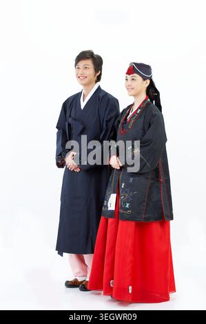 Un homme et une femme se tiennent ensemble, tous deux habillés en hanbok coréen traditionnel. Banque D'Images