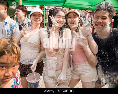 Groupe de jeunes couverts de pâte blanche appréciant le festival Songkran à Lampang, Thaïlande. Banque D'Images
