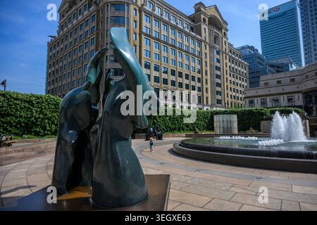 Sculptures modernes en bronze à Cabot Square, Canary Wharf, entouré de tours de bureaux dans le quartier financier de Londres sous un ciel bleu clair. Banque D'Images