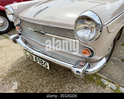 Gros plan de la calandre avant, du phare et du pare-chocs d'une voiture classique Austin Cambridge beige vintage garée à l'extérieur Banque D'Images