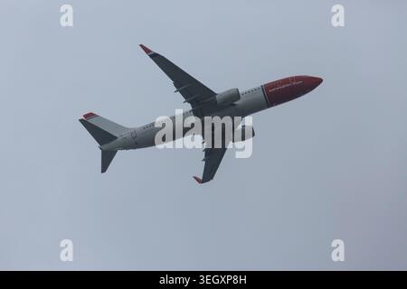 Avion norvégien Boeing 737-800 se-RPM en montée après avoir quitté l'aéroport de Gatwick West Sussex UK vu du comté voisin dans le Surrey Banque D'Images
