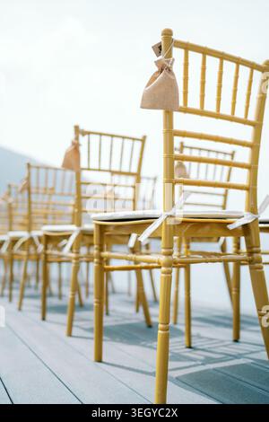 Mariage en bord de mer avec sièges dorés. Chaises élégantes et brise douce pour un mariage pittoresque en bord de mer Banque D'Images