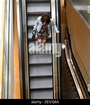 Au-dessus de la femme sur l'escalier roulant Banque D'Images