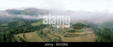 Campagne paisible avec des collines luxuriantes. Environnement rural idyllique avec des pentes douces et des fermes dispersées Banque D'Images