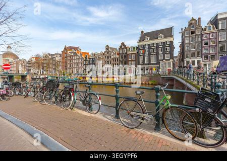 Vélos garés et barges amarrés sur le canal en face des maisons traditionnelles, Singel, Amsterdam Banque D'Images