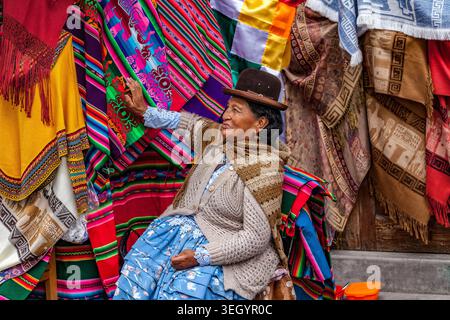 Une femme locale, cholita, portant le chapeau melon traditionnel, la bombine, vend ses produits tissés à la Paz, en Bolivie Banque D'Images