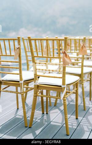 Chaises dorées de cérémonie de mariage en plein air avec sacs cadeaux Banque D'Images