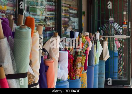 Toronto, Ontario, Canada - 17 mai 2026 : plusieurs rouleaux de tissu empilés et exposés à l'extérieur d'un magasin de tissu dans le centre-ville de Toronto, montrant te coloré Banque D'Images