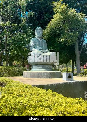 Statue de Bouddha assise dans les jardins du temple Senso-ji à Asakusa, Tokyo, Japon. Banque D'Images