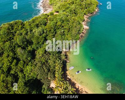 Vue aérienne de Jungle Beach avec des eaux turquoises, forêt tropicale luxuriante, et de petits bateaux ancrés près de la côte Unawatuna, Sri Lanka. Banque D'Images