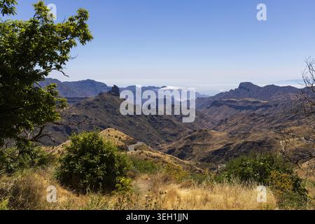 Prairies sèches avec des pics montagneux volcaniques et des vallées stratifiées dans les hautes terres intérieures de Gran Canaria, îles Canaries. Banque D'Images