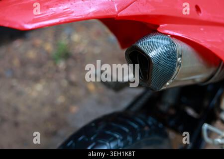 Gros plan détaillé d'une moto rouge avec un puissant tuyau d'échappement en fibre de carbone. le design moderne montre la vitesse, la performance et la passion pour le sport automobile et Banque D'Images