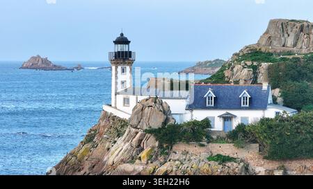 Vue aérienne de l'île Louet avec le phare historique et le chalet du gardien perché sur des falaises rocheuses surplombant la baie de Morlaix à Carantec, Br Banque D'Images