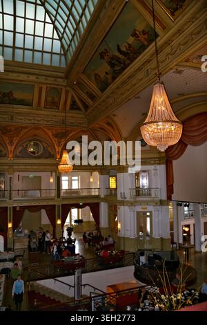 SCHEVENINGEN, LA HAYE, PAYS-BAS - 27 JUIN 2007 : visiteurs à l'intérieur du hall historique de l'hôtel Kurhaus avec lustres, toit en verre et interio peint Banque D'Images