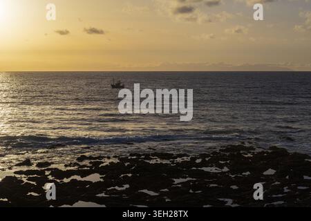 Lumière dorée du coucher de soleil sur l'océan Atlantique vue de la côte rocheuse près d'Agaete, Gran Canaria, îles Canaries, Espagne. Banque D'Images