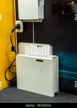 L'invention concerne une unité de batterie résidentielle contemporaine de stockage d'énergie qui se trouve sur le sol à côté d'une station de charge de véhicule électrique et d'un boîtier de commande. Banque D'Images
