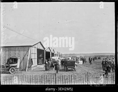 Image d'archive montrant la vue générale des hangars de la semaine de l'aviation de Reims à Bétheny, Marne, France, photographiée par Meurisse en 1909, documentant les premiers monoplans, biplans et la présence du public lors de l'événement aéronautique. Banque D'Images
