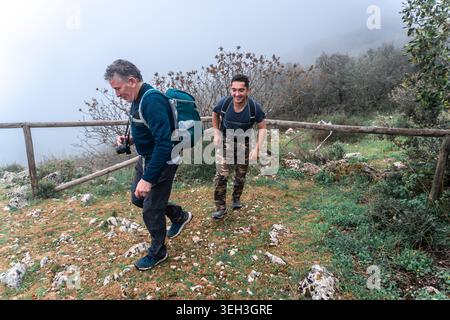 Deux hommes marchant en montée le long d'un sentier de montagne Banque D'Images