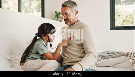 Enfant, jeu et stéthoscope avec père à la maison comme prétendant médecin, évaluation et liaison. Homme, fille et outils médicaux pour le bilan fantastique Banque D'Images